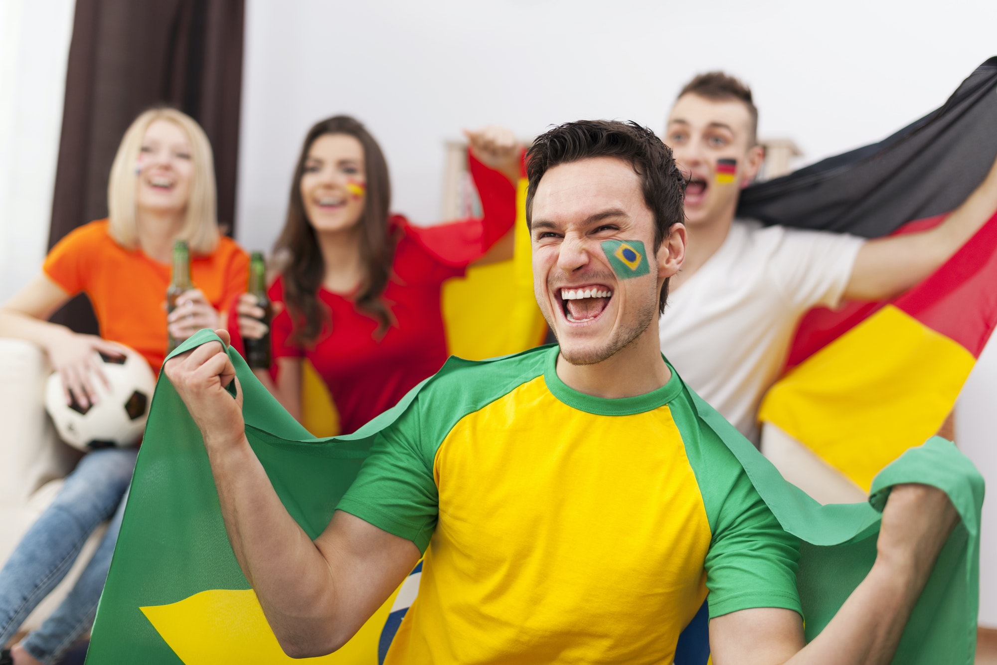 Excited brazilian man with her friends cheering football match