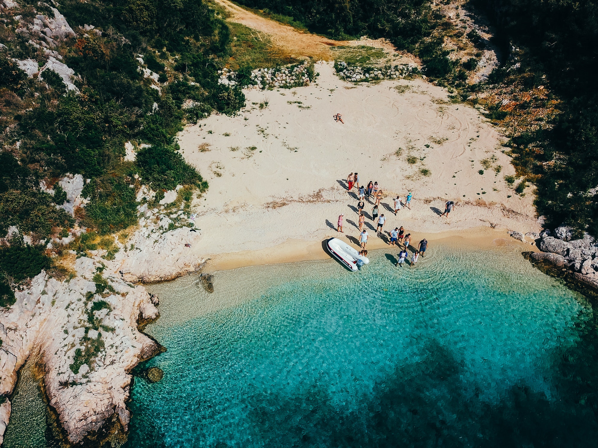 People on a wild beach near a motorboat