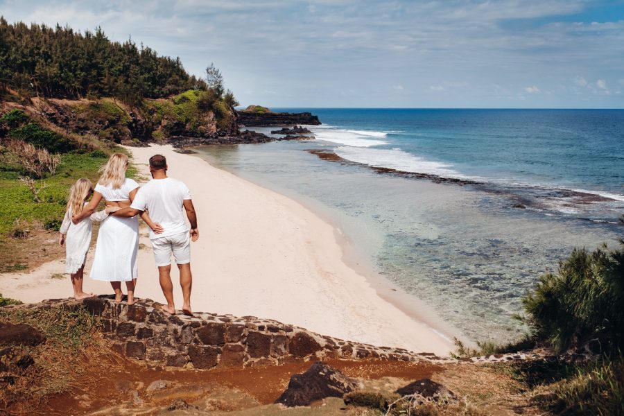 a family in white with three people looks into the distance of Gris Gris beach on the island of