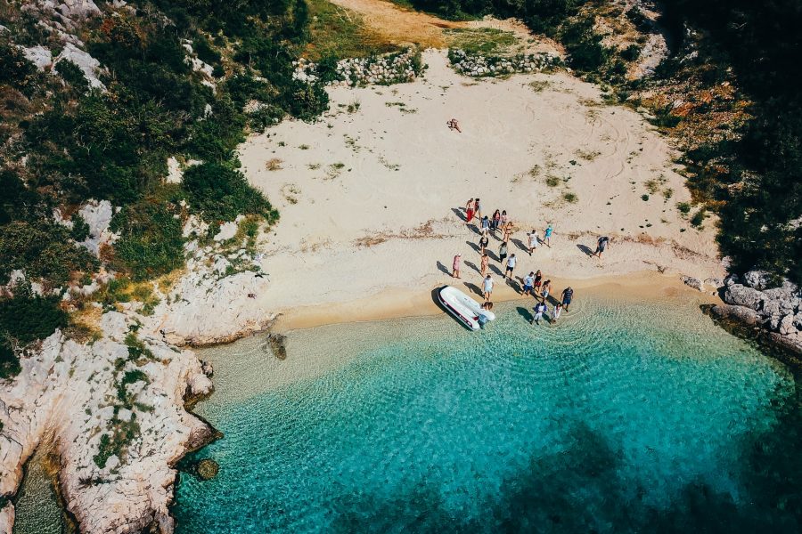 People on a wild beach near a motorboat