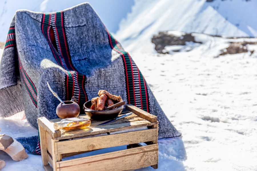 Winter picnic in chilean argentine snow mountaines Andes with hot meat food and drink yerba mate
